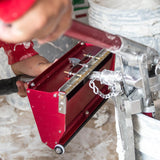 Person using Level 5 box filler attached to a compound pump to load mud from a bucket into a Level 5 flat box